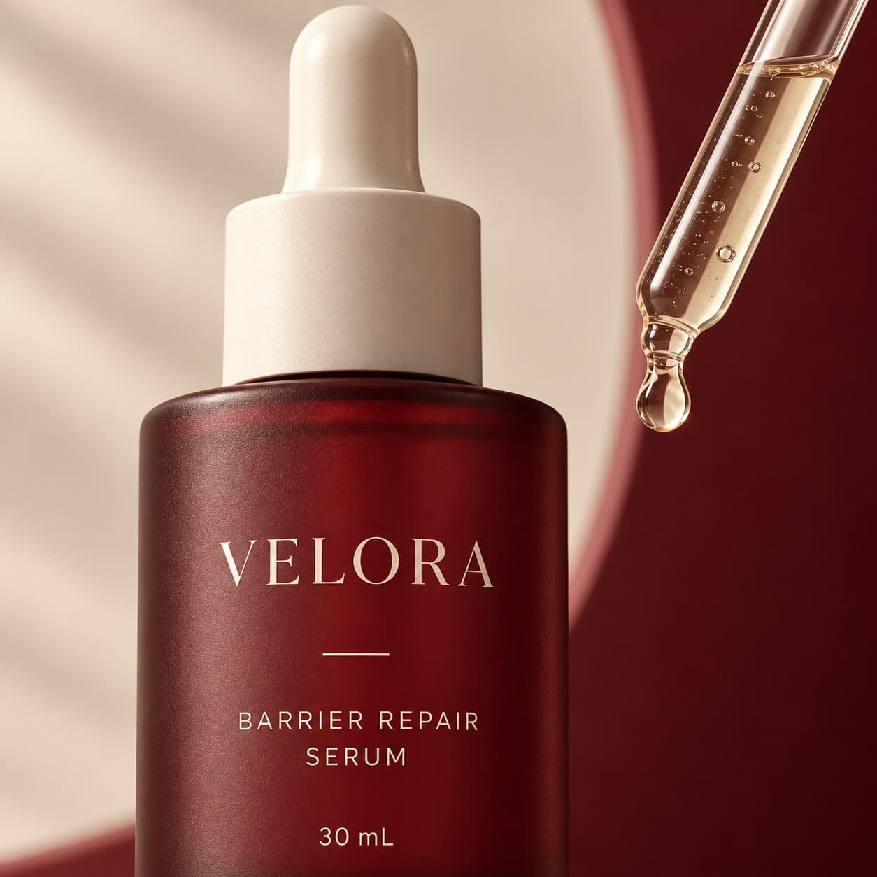 Macro detail — the serum bottle's frosted burgundy glass and cream cap, with a loaded pipette above it.