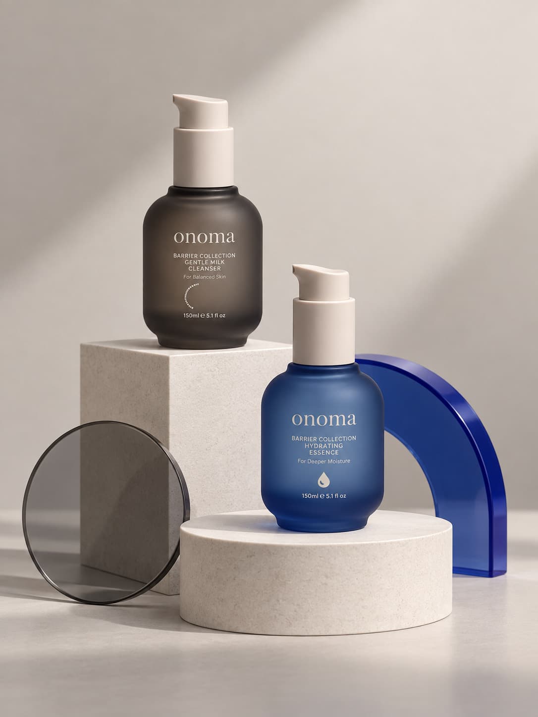 The barrier collection — the charcoal gentle milk cleanser and the blue hydrating essence on stone plinths beside a cobalt glass arch.